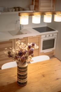 um vaso de flores sentado numa mesa numa cozinha em BAY BREEZE Holiday house in Piran em Piran