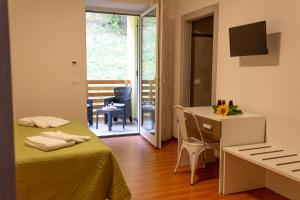 a room with two beds and a desk and a table at Agritur Maso Valli in Borgo