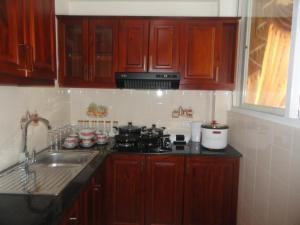 a kitchen with wooden cabinets and a stove and a sink at City And Hills View Apartment in Nuwara Eliya