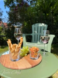 a table with two glasses of wine and a plate of food at Wellness cottage met hottub 'Auckland' by Kawatea in Ewijk