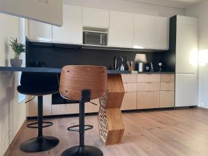a kitchen with a counter and two bar stools at Hexagon Apartman Szeged in Szeged