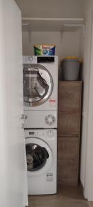 una lavatrice e un'asciugatrice in una piccola stanza di Casa Memole a Levico Terme