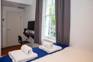 um quarto com uma cama com duas toalhas em Putera Puteri Residence em Londres