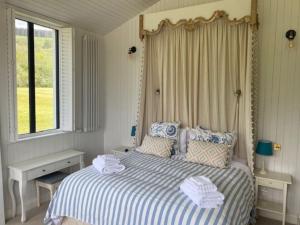 a bedroom with a bed with two towels on it at Harry's Cottage in Aghanloo