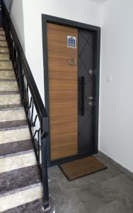 a wooden door with a sign on it next to stairs at MP Apartman in Soko Banja
