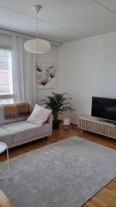 a living room with a couch and a rug at Bright apartment, airport 3km, private parking, sauna in Vantaa