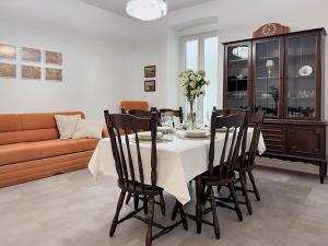 a dining room with a table with chairs and a couch at Apartment Villa Elsa in Portorož