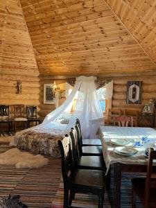 a bedroom with a bed and a table and chairs at Tagavälja talu Cottage and Sauna on a farm B&B, rural experience in Atsalama