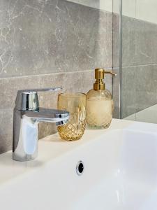 a bathroom sink with a soap dispenser and a bottle at Apartment Villa Elsa in Portorož +26 photos