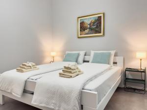 a white bedroom with two beds with towels on them at Apartment Villa Elsa in Portorož