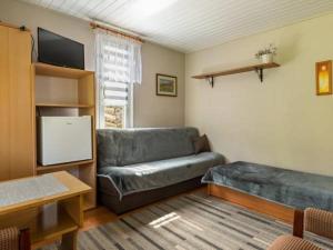 a living room with a couch and a tv at U Beaty in Ruciane-Nida