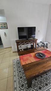 sala de estar con TV y mesa de centro en Acogedor departamento 1 dormitorio en El Palomar