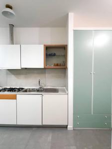 a kitchen with white cabinets and a sink at Non ti scordar di me #2 in Pieris