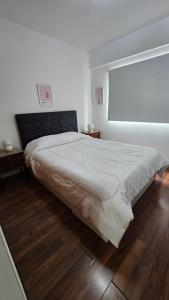 Schlafzimmer mit einem großen Bett und einem Fenster in der Unterkunft Acogedor departamento 1 dormitorio in El Palomar