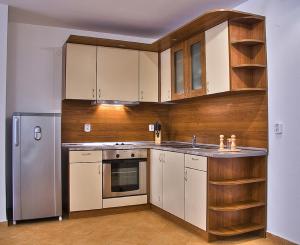 a kitchen with white cabinets and a stainless steel refrigerator at Montemar Villas in Sunny Beach