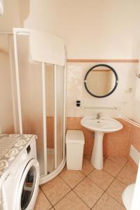 een badkamer met een wasmachine en een wastafel bij Villaggio polifemo 38 Località Cala Sapone in Cala Sapone