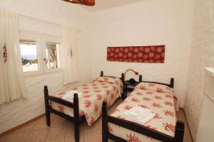 a bedroom with two beds and a window at Villaggio polifemo 38 Località Cala Sapone in Cala Sapone