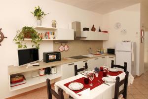 een keuken met een tafel en stoelen en een keuken met bij Villaggio polifemo 38 Località Cala Sapone in Cala Sapone