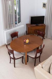 una mesa y sillas en una sala de estar con TV en Villa Christina, en Katsíngrion