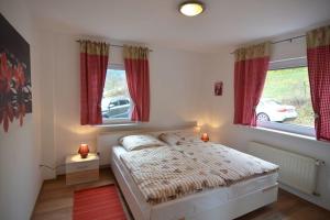 a bedroom with a bed and two windows at Olsberg Elpe in Elpe