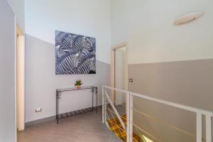 un pasillo con una escalera y una pintura en la pared en Napoli Relax Rooms Chiaia - Mergellina - Posillipo, en Nápoles