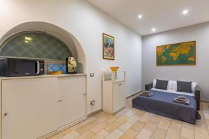 Una habitación con una cama y un televisor en la pared. en Napoli Relax Rooms Chiaia - Mergellina - Posillipo, en Nápoles