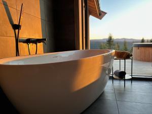 a white bath tub in a bathroom with a window at Snowcake Cottage in Sør-Fron +39 photos
