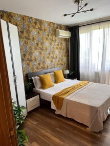 ein Schlafzimmer mit einem großen Bett mit gelben Kissen in der Unterkunft Lighthouse Golf Resort & Spa Apartments in Baltschik