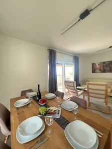 a dining room with a table with plates and wine glasses at Apartment DELFIN Jacuzzi , Bribir-Novi Vinodolski in Bribir