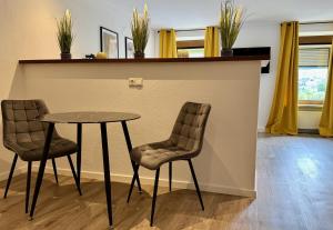 a table and two chairs next to a counter at VonMos Moselblick Apartments in Kinheim