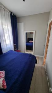- une chambre avec un lit bleu et un miroir dans l'établissement Central Comfort Room in heart of Oslo, Majorstuen, à Oslo