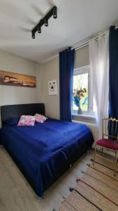- une chambre avec un lit bleu et une fenêtre dans l'établissement Central Comfort Room in heart of Oslo, Majorstuen, à Oslo