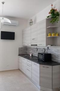 a kitchen with white cabinets and a black counter top at Casa Luce in Marina di Massa