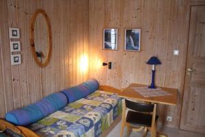 1 dormitorio con 1 cama y pared de madera en Gunnabuda, en Longva