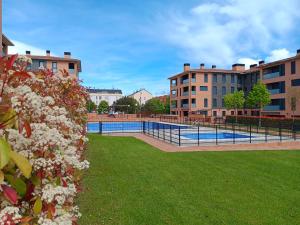 a swimming pool in the middle of a park with flowers at Camino Santiago Etxea in Jaca