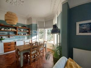 uma cozinha e sala de jantar com mesa e cadeiras em Beautiful Victorian Seaside House em Clevedon