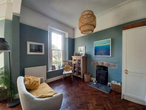 a living room with a couch and a fireplace at Beautiful Victorian Seaside House in Clevedon