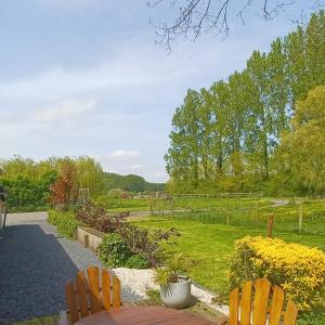 un jardín con 2 sillas y un campo de flores en Nature et Moi, en Wittes