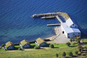 an island with houses and a dock in the water at Gunnabuda in Longva