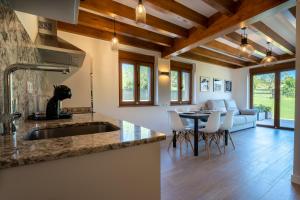 a kitchen with a sink and a table with chairs at Apartamentos Rurales Quintanilla in Penagos