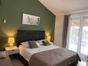 1 dormitorio con cama y pared verde en Apartments Villa Mirella 20 m from the sea - free parking en Trogir