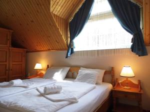 a bedroom with two beds and two windows at Millennium Villa in Keszthely