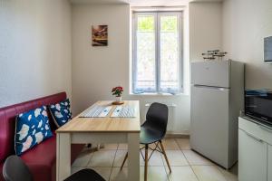 eine kleine Küche mit einem Tisch und einem Kühlschrank in der Unterkunft La cabane bleue, T1 à Narbonne in Narbonne