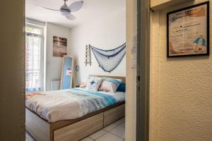 1 dormitorio con cama y ventana en La cabane bleue, T1 à Narbonne en Narbona