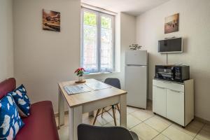 Habitación pequeña con mesa y nevera. en La cabane bleue, T1 à Narbonne en Narbona