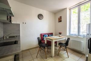 cocina con mesa y sillas en La cabane bleue, T1 à Narbonne en Narbona