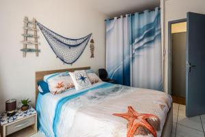 Un dormitorio con una cama con una estrella de mar. en La cabane bleue, T1 à Narbonne, en Narbona