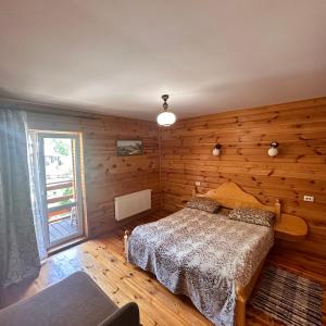 1 dormitorio con 1 cama y pared de madera en Kipreya, en Yaremche