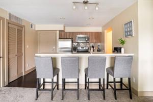 a kitchen with a bar with four chairs in it at Harbor Views ,Luxury Condo, Venice&Marina in Los Angeles