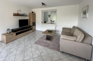 a living room with a couch and a television at Ferienwohnung Eifel-Ring in Siebenbach